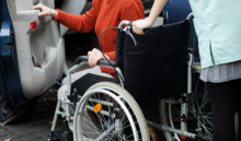 girl on a wheelchair pushed through towards the van